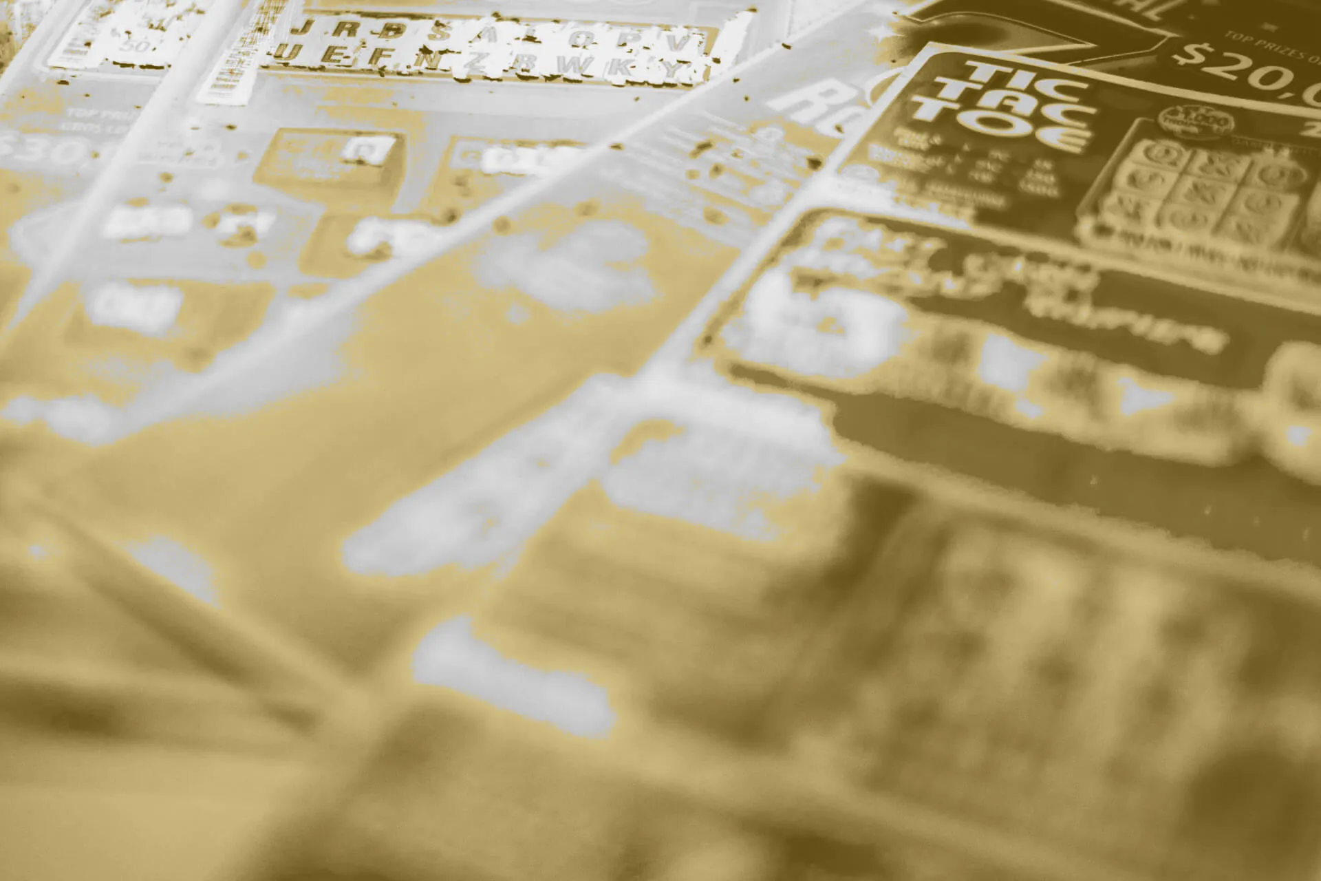 A close-up view of several UK lottery scratch cards spread out in a fan-like arrangement. The scratch cards display various games and prize amounts, including titles like “Tic Tac Toe.” The image has a gold-tinted overlay, giving it a stylised, monochromatic look.